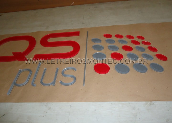 Letreiro de acrílico cristal sendo produzido com recorte a laser e adesivo colorido colocado na parte de trás para a empresa HQS Plus