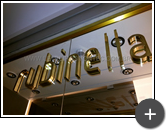 Letreiro da fachada das redes de lojas de roupas da Rubinella em latão polido instalado